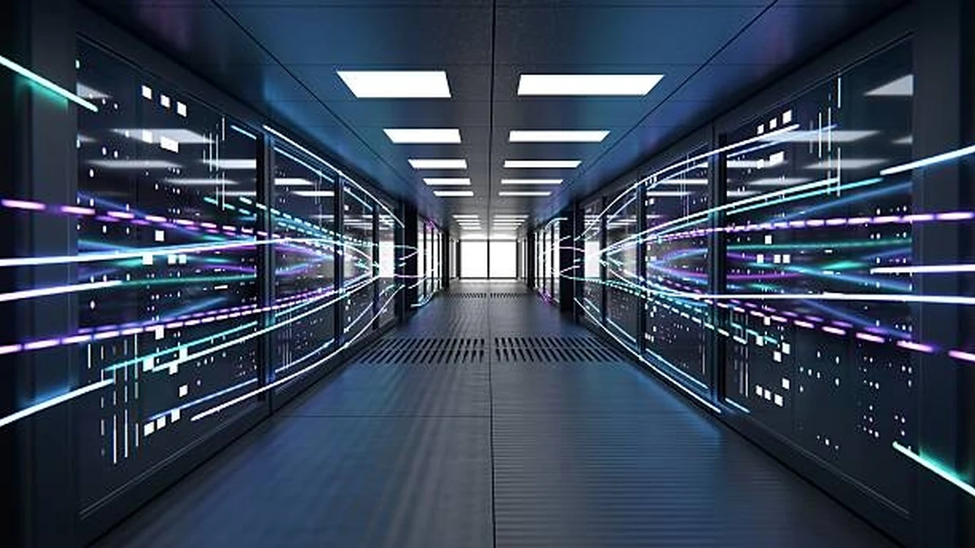 A long data center corridor between server racks streams cyan and violet light along the aisle.